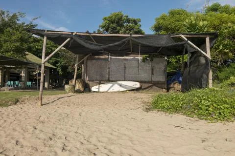 The shack on the beach side is used to put surf boards and other water sports Stock Photos
