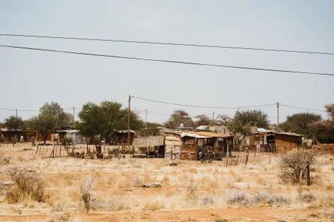 Shacks outside in the desert between sand and bushes in Africa Stock Photos