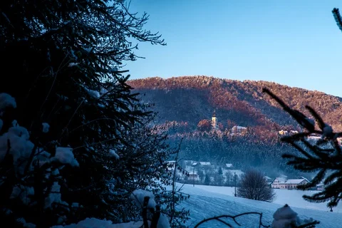Shade moving timelapse during sunrise over snow covered church on the hill Stock Footage 129341497