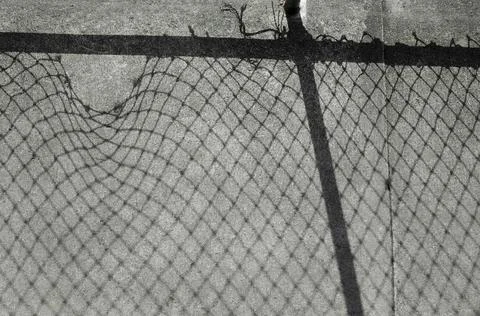 Shade of Shadow Hole of Wire Mesh Fence on Ground Foto stock