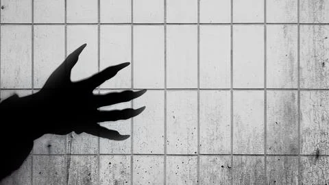 Shade of werewolf hands with claws on a tile wall background. The hand is r.. Stock Photos
