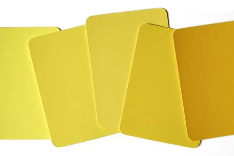 Shades of yellow color sample cards scattered on a table Stock Photos