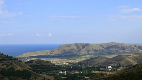 Shadow is approaching the city in the valley. Mountains against the blue sky Stock Footage 99362462