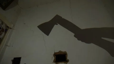 Shadow of an axe on a wall, creating a grim and mysterious atmosphere Stock Footage 277872182