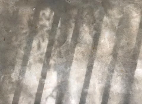 Shadow from baluster bar and small tree leaves shine on gray cement Stock Photos