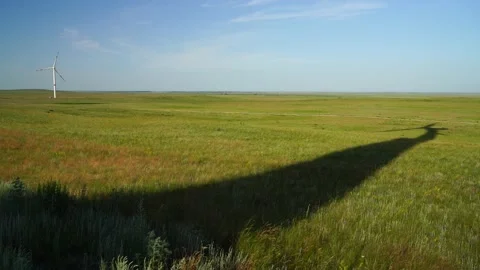 Shadow of blades of a large wind turbine in a field with green grass Stock Footage 160253167