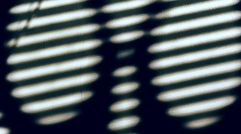 Shadow from the blinds through the handles of the scissors. Photos