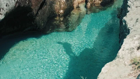 Shadow On The Bottom Of A Crystal Clear River, Of A Man Jumping From A Ledge Stock Footage 94032056