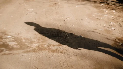 Shadow of a boy walking on a dirt sandy road. Cool shots. Very cinematic Stock Footage 128016321