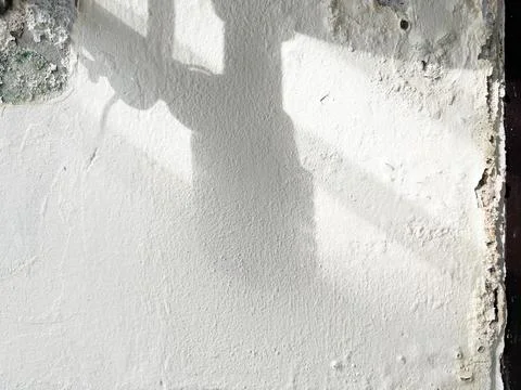Shadow of broken washbasin drain pipe on damped, musty wall. Stock Photos