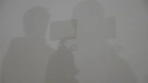 Shadow of a cameraman on a white surface Vídeo Stock 223104873