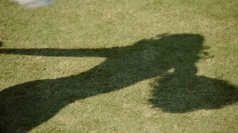 Shadow of a cheerleader dancing on the NFL field on a sunny day Stock Footage 113276814