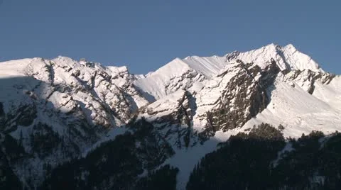 Shadow creeping up snow covered mountain Video stock 10813180
