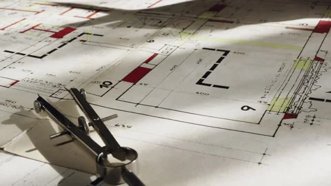 Shadow of draftsman fidgeting with tool falls across blueprint drawing Stock Footage 311786942