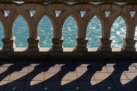 A shadow falls on the pavement from patterned balusters. Foto stock