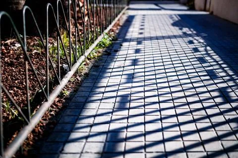 Shadow of the fence on the pavement Stock Photos