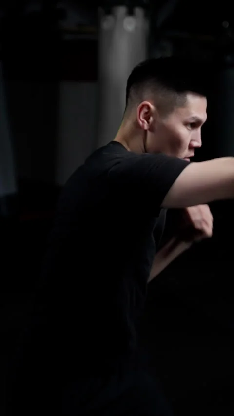 Shadow fighting. A man in a black T-shirt makes a series of quick punches. Slow Stock Footage 260147102