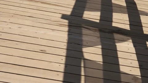 Shadow of flags blowing in the wind on wooden bridge Stock Footage 194729421