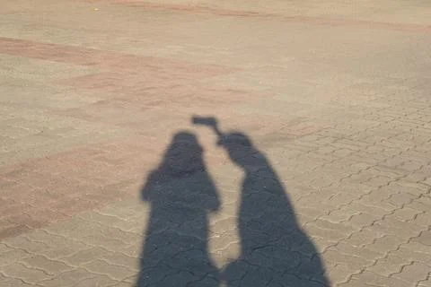 Shadow on The Floor of Two People Stock Photos