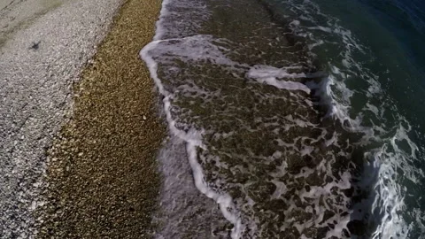 The shadow of a flying phantom over the coast line moves along the beach Stock Footage 86787586