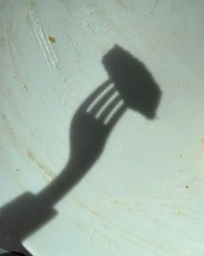 Shadow of a fork on a plate Stock Photos