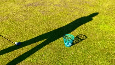 Shadow of a Golfer Training Golf Swing with 3 Wood on the Grass with Success 動画素材 194012087