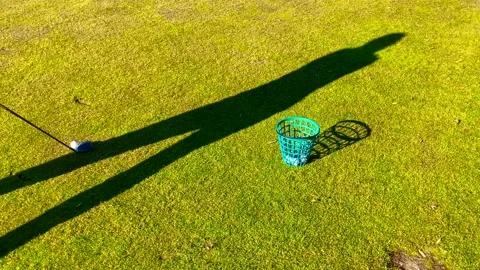 Shadow of a Golfer Training Golf Swing with 3 Wood on the Grass with Success Stock Footage 194012094