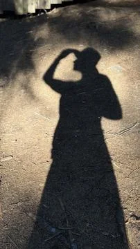 Shadow on Ground with Hat and Arm Raised in Salute Stock Photos