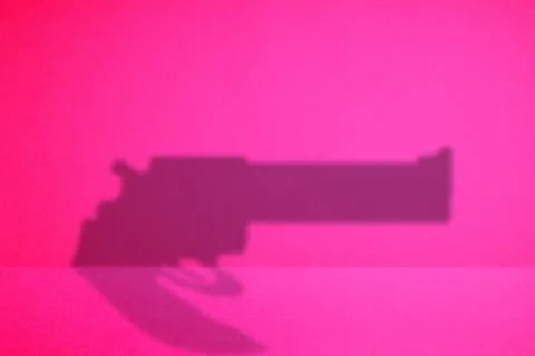 The shadow of a gun in the red background. Stock Photos
