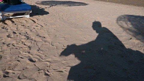 The shadow of a guy holding his head against the background of sand Stock Footage 271141018