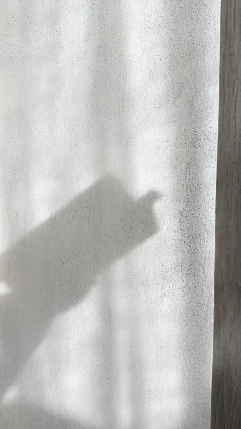 Shadow of Hand Flipping Book Pages on Brutalist Concrete Wall Vertical Stock Footage 339433583