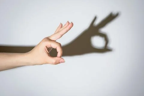 Shadow of a hand making an Okay symbol Stock Photos