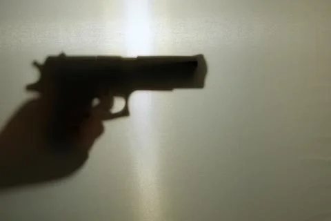 Shadow of a hand with a pistol Stock Photos