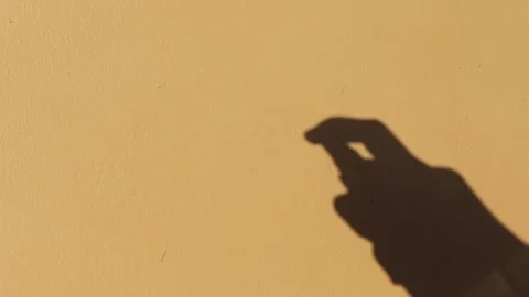 Shadow of hand is spraying alcohol to sterilize the air Stock Footage 153806375