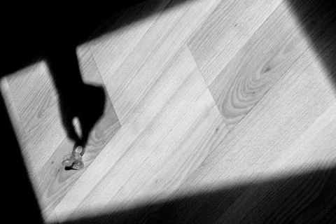 The shadow of a hand takes a pacifier from the floor. Stock Photos