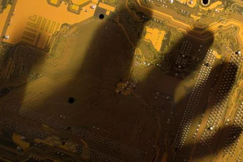 Shadow by hand on the yellow computer mainboard. 写真素材