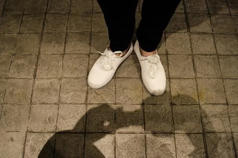 The shadow the hands of a man holding a camera on the concrete floor of an ur Stock Photos
