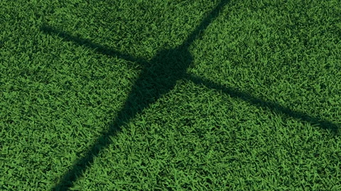 Shadow of a helicopter on a landing pad. Grass bends from the powerful rotation Stock Footage 127919863