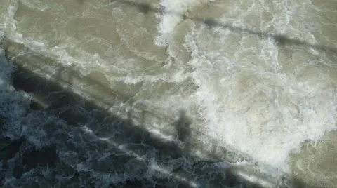 Shadow of hikers on a bridge over muddy stream of river Stock Footage