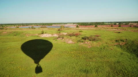 Shadow of a hot air balloon on a green meadow on a sunny summer day Stock Footage 265776364