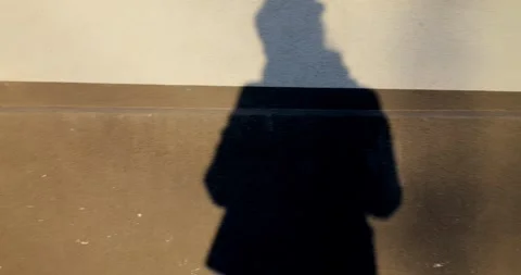 Shadow of human gradually changing on two tone wall, projecting subtle Stock Footage 309046494