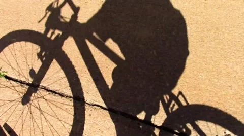 Shadow of a Kid Biking on Cement Stock Footage 42773802