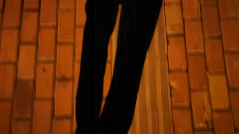 A shadow of the legs of a man walking forward on the road at night. Stock Footage 156634505