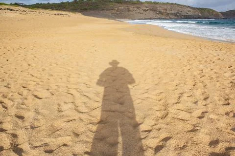Shadow of a lonely man on a beach Stock Photos
