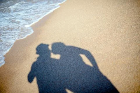 A shadow of lovers on the sand on the beach 库存照片