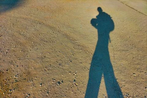 Shadow of a man with a backpack walking in the evening with long soft shado.. Stock Photos