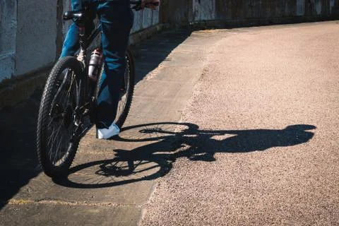 Shadow of a man on a bicycle with copy space. Stock Photos