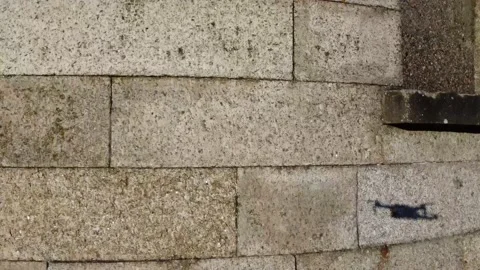 Shadow of a man catching drone on the wall. Boy and drone  Stock Footage 168495712