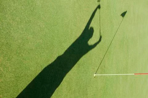 Shadow of man cheering on golf course Stock Photos