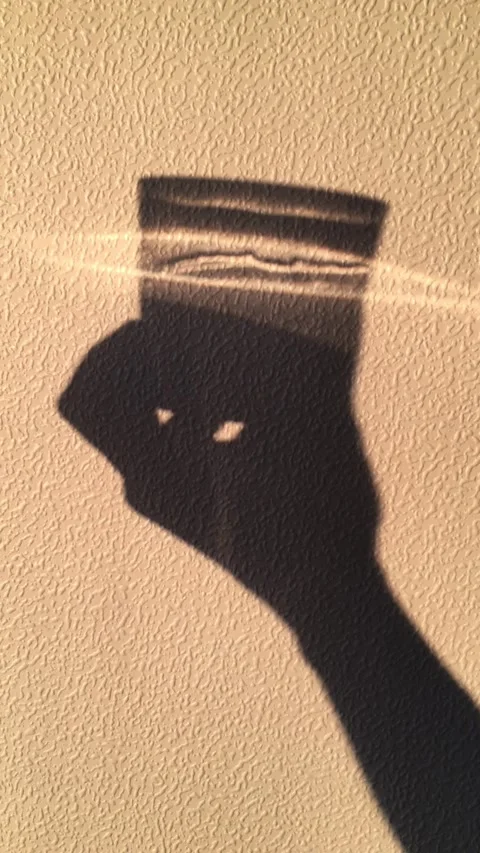 Shadow of a man with a cup drinking water, shadows of sunrise or sunset. Light Stock Footage 314501594